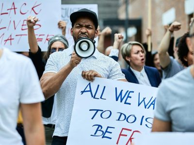 multiethnic-crowd-people-protesting-against-racism-city-streets-focus-is-african-american-man-shouting-through-megaphone_637285-7147